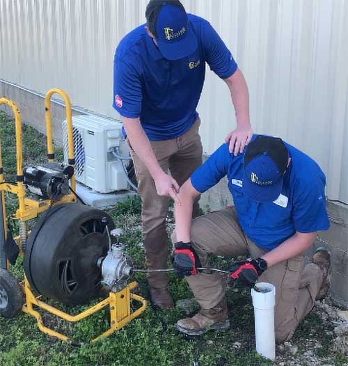 Kinsey plumbers snaking a drain.